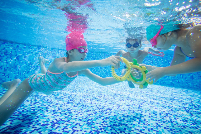 kids-swimming-underwater-and-playing-with-toys-PPVGB2D.jpg
